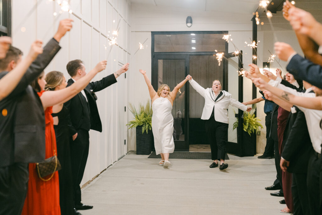 Wedding couple runs through the sparklers after their wedding day comes to an end. 