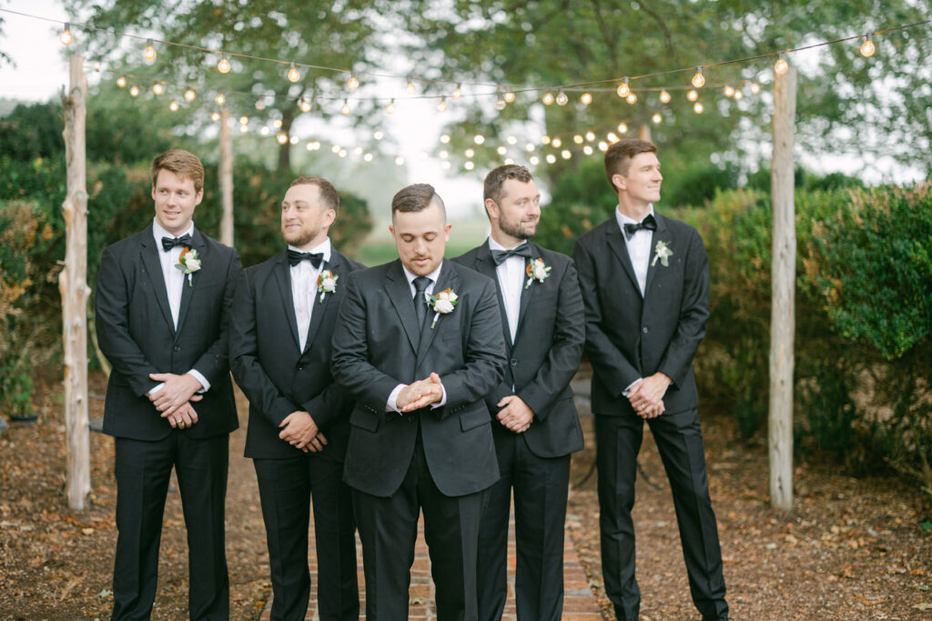 Groomsmen pose with the groom on his wedding day. 